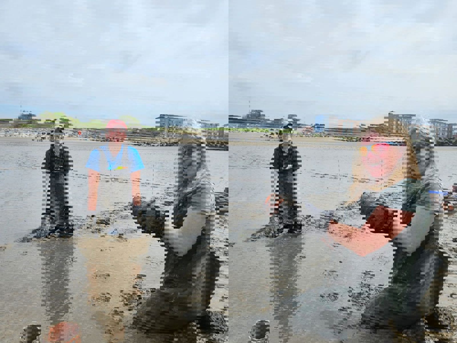 [Carmarthen Bay & Estuaries European Marine Site Officer Judith and Project Seagrass South and West Wales Project Lead Emma are wearing waders and kneeling in muddy sediment at Llanelli beach as they collecting cores.] 
